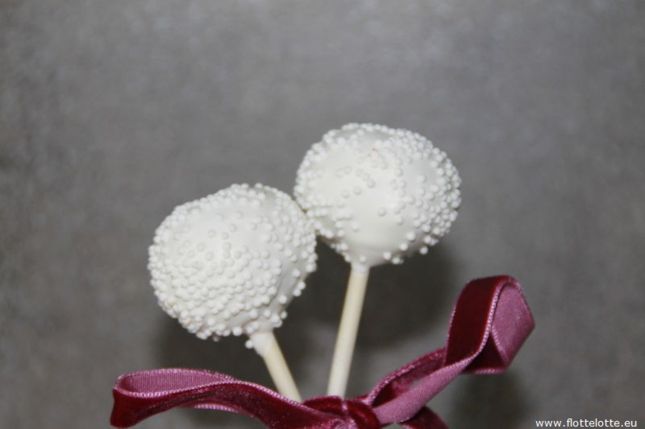 Wälzen Sie Cake Pops in weißen Mini-Zuckerperlen für Hochzeiten